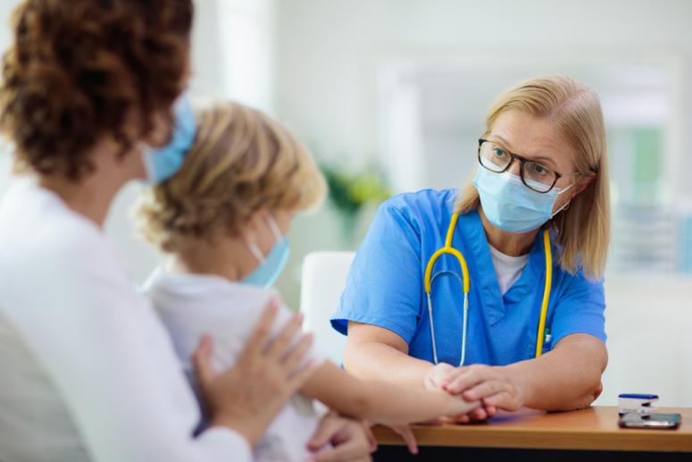 child in mask with doctor in scrubs and mask