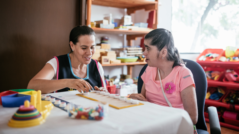 Woman playing with a girl with a disability